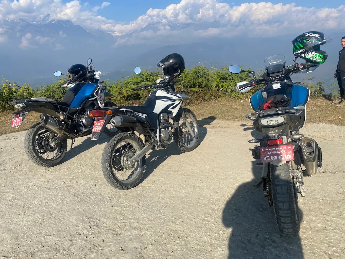 Three adventure motorcycles on a mountain viewpoint